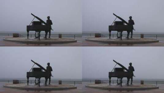 雪花纷飞之中的海上钢琴师雕像威海高清在线视频素材下载