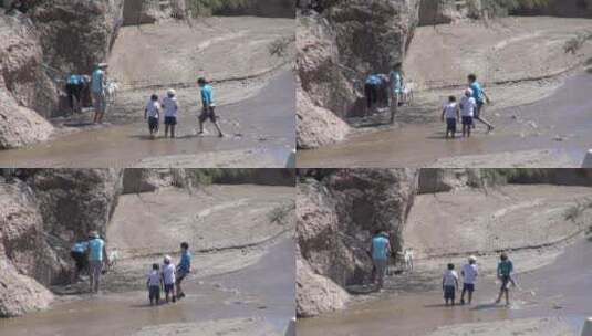 游客在岩石附近的溪流中涉水高清在线视频素材下载