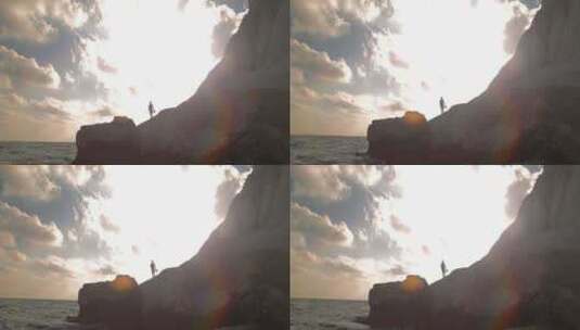 摄影师站在岩石海岸观看太阳高清在线视频素材下载