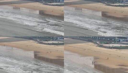 航拍俯瞰威海金海湾海水浴场的沙滩海浪高清在线视频素材下载