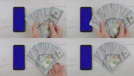 在手机旁数钞票高清在线视频素材下载