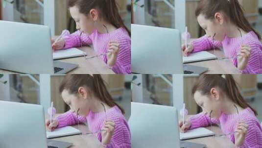 女学生使用笔记本电脑做笔记高清在线视频素材下载