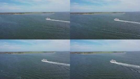 在一个阳光明媚的日子里，一架无人驾驶飞机俯瞰琼斯湾。摄像机向一艘旅游船飞去高清在线视频素材下载