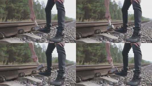 一个戴着头盔的铁路工人修理铁路，用大锤锤高清在线视频素材下载