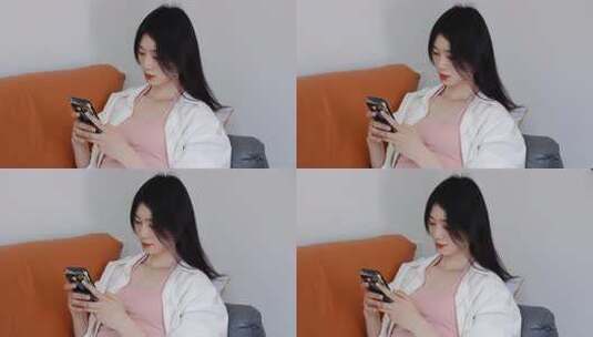 女子沙发上专注看手机高清在线视频素材下载