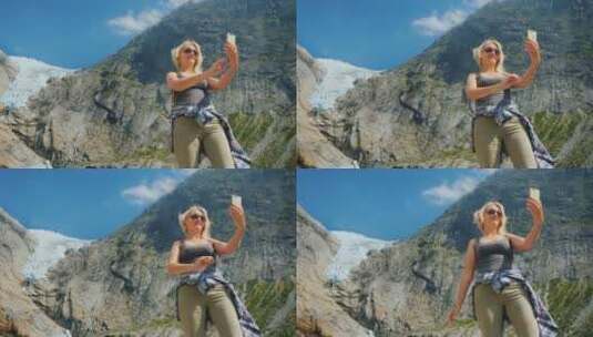 一个漂亮的女人在山的背景下给自己拍照高清在线视频素材下载