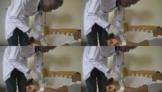 一名非洲医生俯身帮助一名卧病在床的非洲妇女注射药物高清在线视频素材下载