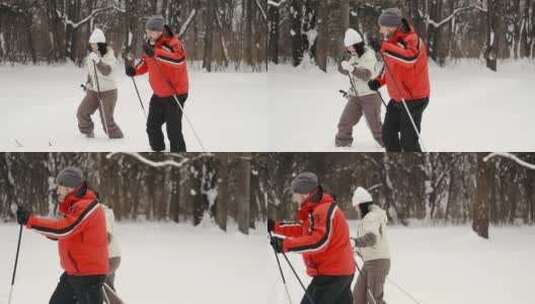 一男一女拿着登山杖在雪地里行走高清在线视频素材下载