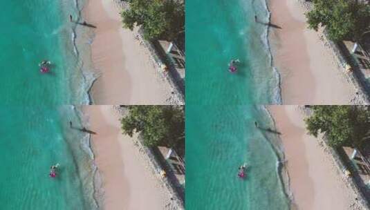 航拍游客在海滩上游泳高清在线视频素材下载
