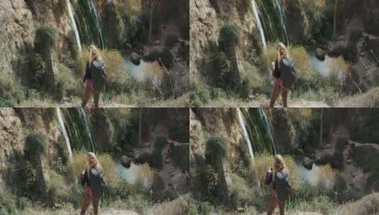 女人用手机拍摄山间瀑布高清在线视频素材下载