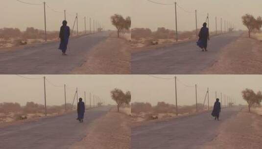 在沙漠路上行走的男人高清在线视频素材下载