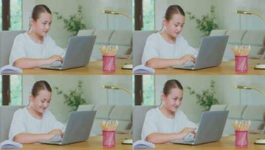 可爱的少女坐在书桌前，带着笔记本电脑，写着微笑的笔记、铅笔和一盏灯高清在线视频素材下载