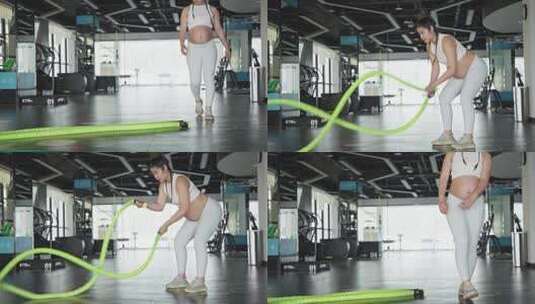 怀孕的妇女在健身房练习战绳锻炼身体高清在线视频素材下载