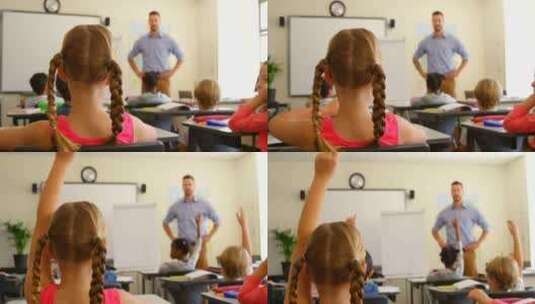 多民族学童坐在学校教室的桌子前举手4k高清在线视频素材下载