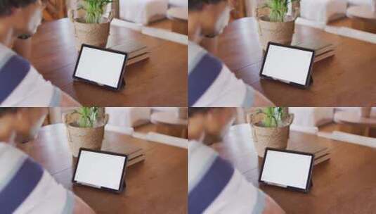 一个男人坐在桌旁使用平板电脑高清在线视频素材下载