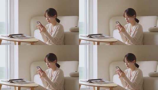 室内女子坐沙发看手机高清在线视频素材下载