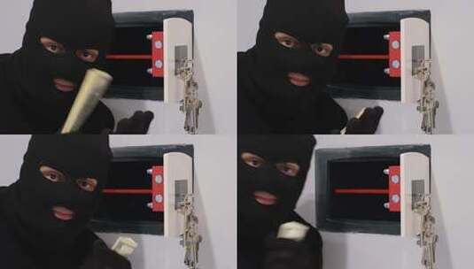 一个戴着黑色面具的强盗打开保险箱偷钱高清在线视频素材下载