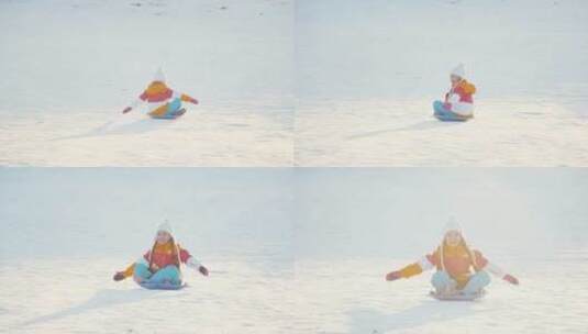 孩子坐在雪盘上从雪山上滑下来高清在线视频素材下载