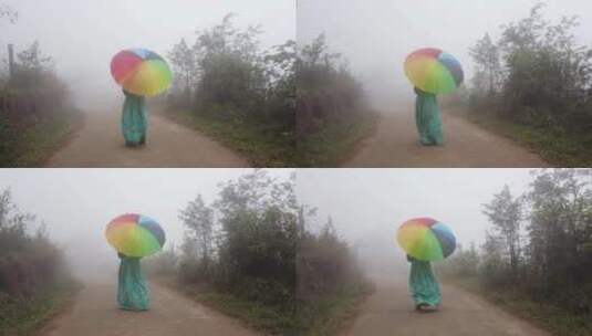 女孩打着雨伞在晨雾中行走高清在线视频素材下载