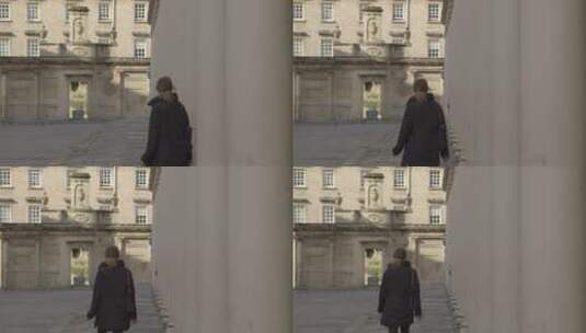 一个穿黑衣服的女人在旧石柱之间行走的宽镜头高清在线视频素材下载