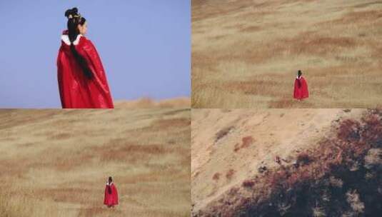 女孩身穿红色斗篷站在大漠高清在线视频素材下载