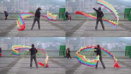 中年女性舞动彩色飘带的户外场景高清在线视频素材下载
