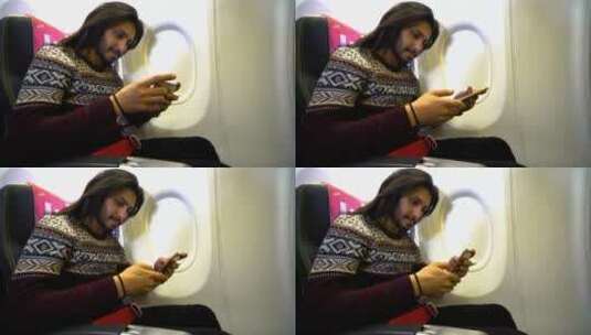男人坐在飞机上玩手机高清在线视频素材下载