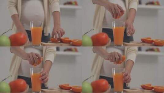 一个怀孕的女人在榨新鲜的橙汁高清在线视频素材下载