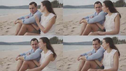 度假夫妇坐在海边的沙滩上微笑高清在线视频素材下载