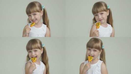 女孩吃棒棒糖对镜头微笑高清在线视频素材下载