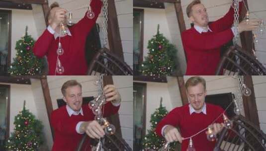 男子在吊篮上挂圣诞灯高清在线视频素材下载