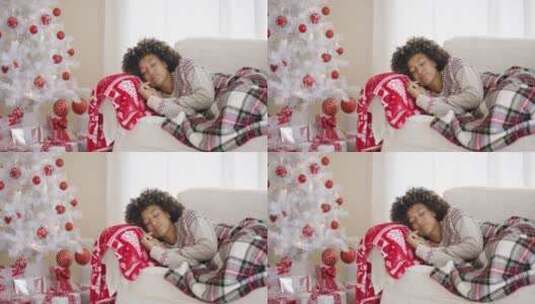睡在圣诞树旁沙发上的女人高清在线视频素材下载