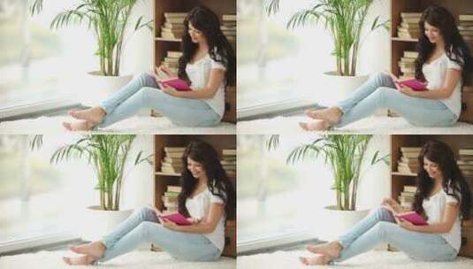 女孩坐在地毯上看书高清在线视频素材下载