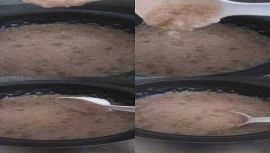 用勺子搅拌锅里煮好的粥高清在线视频素材下载