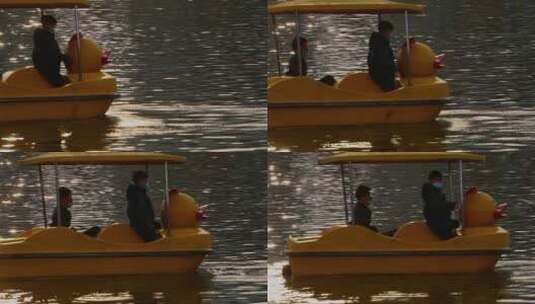 春节期间人们在公园波光粼粼的湖里划船高清在线视频素材下载