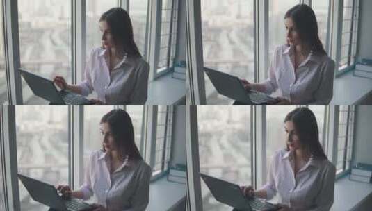 女子坐在窗边拿着笔记本工作高清在线视频素材下载