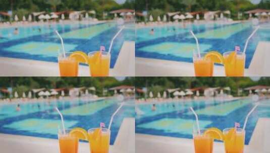 摆在泳池前的两杯橙汁高清在线视频素材下载