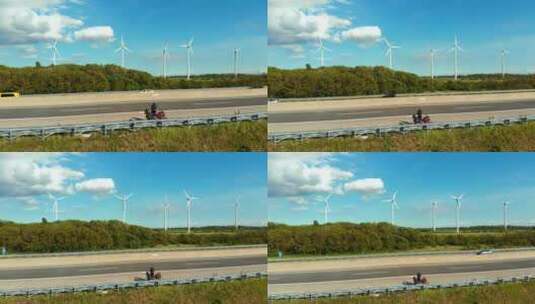 高速公路上的摩托车_后面有一个风力发电场高清在线视频素材下载