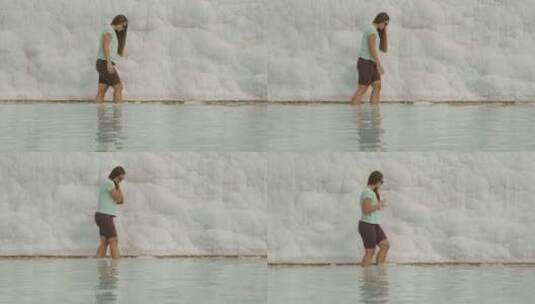 女人小心翼翼地走在水面上，抓住一块白色的高清在线视频素材下载