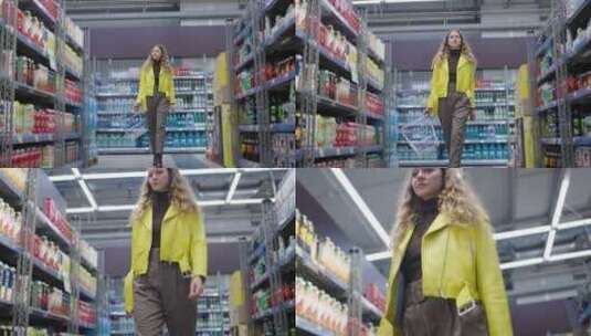 穿着醒目黄色夹克的年轻女子自信地走在超市高清在线视频素材下载