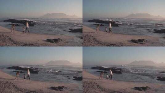 三口之家在海滩上散步的温馨镜头高清在线视频素材下载