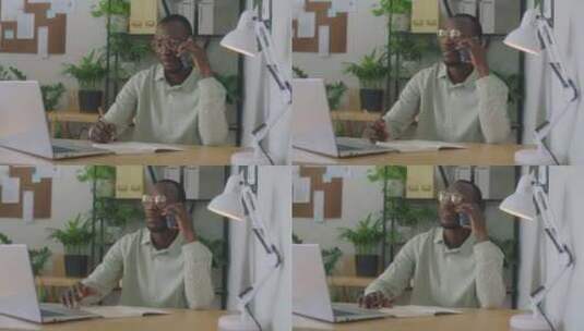 黑人商人在办公室打电话和做笔记高清在线视频素材下载