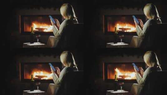 女人在壁炉旁玩手机高清在线视频素材下载