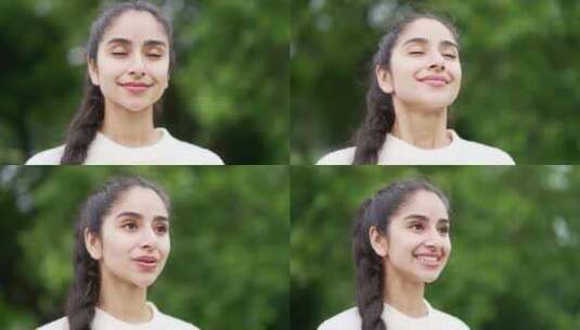 特写肖像年轻快乐的女人站在森林树木之间的高清在线视频素材下载