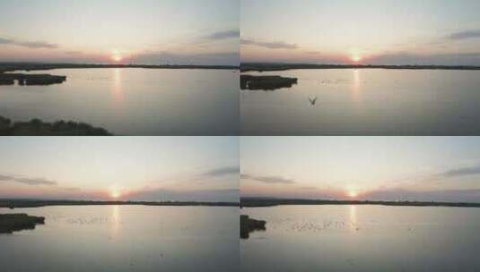 无人驾驶飞机在日落时分飞越湿地高清在线视频素材下载