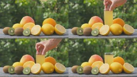 手放在摆着水果的桌子上一杯鲜榨果汁高清在线视频素材下载