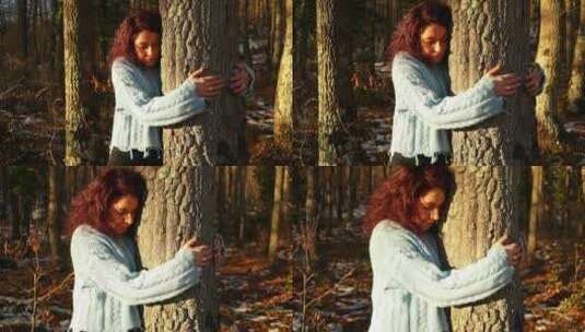 日落时分，年轻的红发白人女孩在树林里拥抱一棵树，中景高清在线视频素材下载