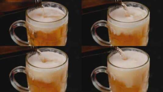 在黑暗的背景下给杯子装满啤酒高清在线视频素材下载