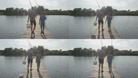 父子拿着鱼竿走在湖边栈道、钓鱼高清在线视频素材下载