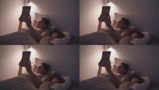 成人晚上和孩子在床上看书高清在线视频素材下载